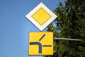 Priority road with side road merging from the left traffic sign