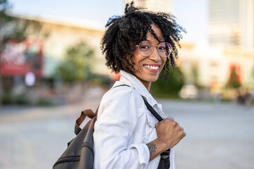 Portrait of a smiling young woman in the city on a sunny day
