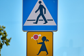Pedestrian crossing sign with children holding lollipop warning sign below