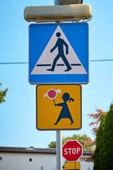 Pedestrian crossing sign with children holding lollipop warning sign below