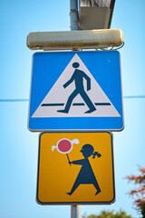 Pedestrian crossing sign with children holding lollipop warning sign below