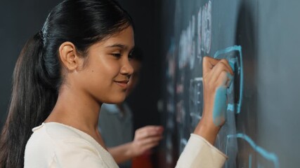 Panorama shot of adult writing engineering prompt on blackboard. Pretty smart student planing a project by using coding and programming system in STEM technology innovative class. Closeup. Edification