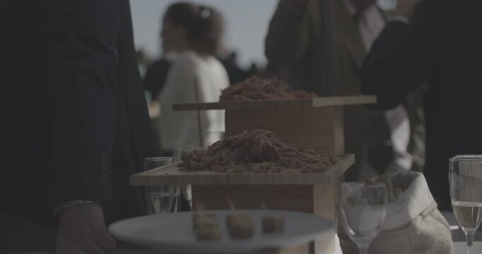Carpaccio de jambon fum&eacute; de Bayonne et petites olives sur pr&eacute;sentoirs en bois lors d'une r&eacute;ception &agrave; un &eacute;v&egrave;nement priv&eacute;