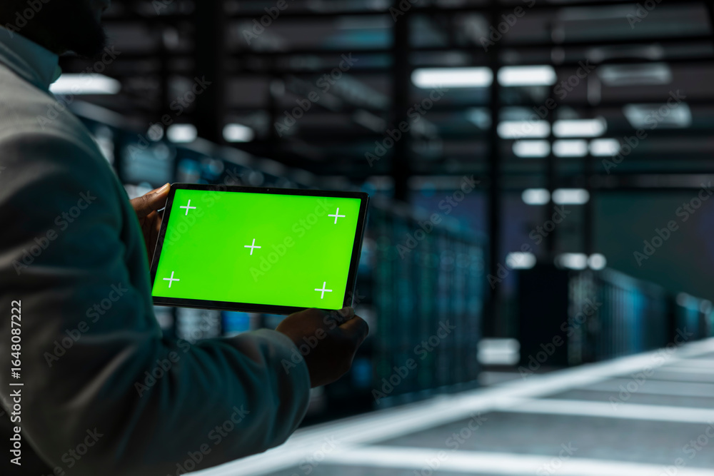 Poster close up of data center admin using green screen tablet, doing checkup to prolong hardware life span