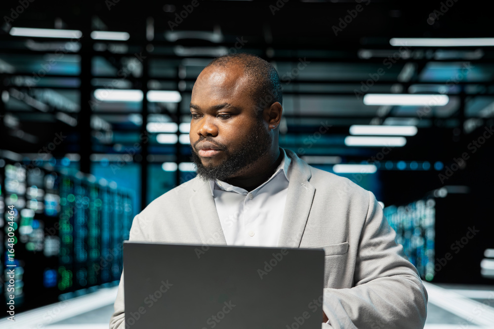 Poster data center admin using laptop, preparing recovery backups, doing checkup to prolong hardware life s