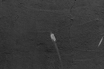 Close-up of aged black wall with cracked paint and worn texture