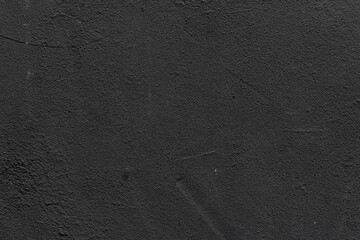 Close-up of aged black wall with cracked paint and worn texture