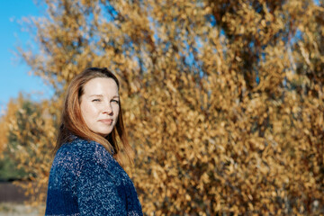 Female portrait. Beautiful young girl with long dark hair on a sunny autumn day outdoors. High...