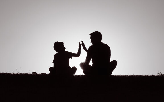 Father giving son high five. Happy parent child relationship concept