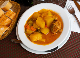 Restaurants guests will have hearty lunch - pork stewed with vegetables, potato, carrots and green...