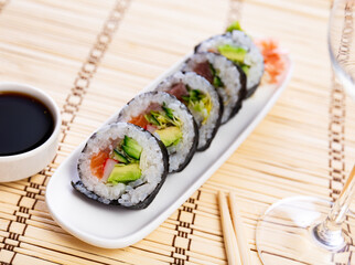 Set of japanese rolls futomaki with soy and chili sauces close-up