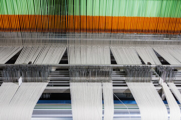 Modern weaving machine with wool warp and heddles in textile manufacturing closeup