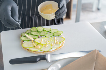 The chef prepares a flatbread with herbs. 