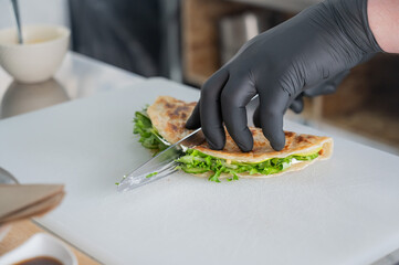 The chef prepares a flatbread with herbs. 