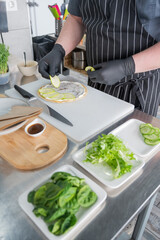 The chef prepares a flatbread with herbs. 