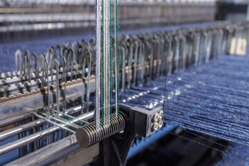 Indigo warp on modern denim loom tensioner in textile factory