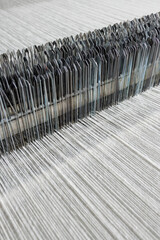Warp threads and heddles on a modern loom in a textile production line