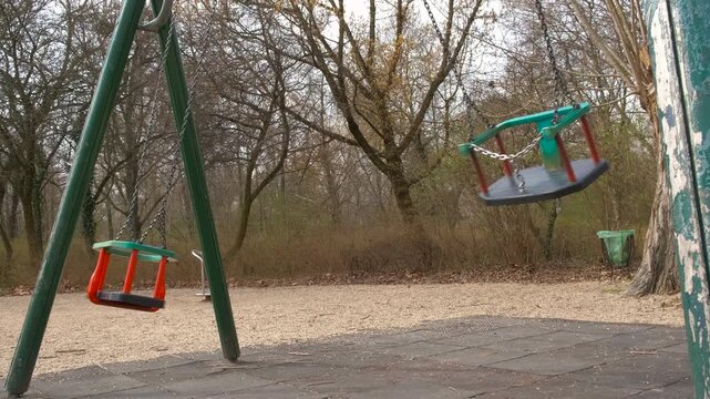 Flying empty carousel on playground. A view of two flying swings on the lonely playground against blue sky