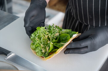 The chef prepares a flatbread with herbs. 