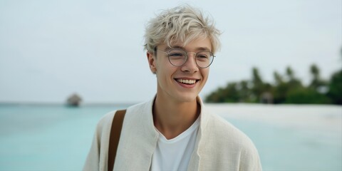 Fototapeta premium Smiling young caucasian male with glasses at tropical beach
