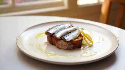 Sardines on toast, gourmet tinned fish, lemon garnish, olive oil drizzle, minimalist plating, preserved seafood, artisanal snack, elegant appetizer, culinary trend, bright kitchen scene