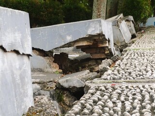Damaged public facilities include cement seating for resting that is not maintained, with the...