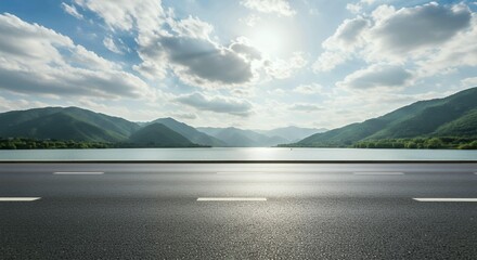 Empty asphalt road with white lane markings stretching toward mountains and lake landscape under dramatic cloudy sky horizon