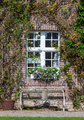 Hausfassade mit weißem Fenster und Sitzbank