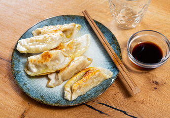 Japanese dish - dumplings gyoza with soy sauce on round plate. High quality photo