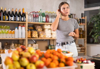 Female shopper has difficulty remembering what to buy at a grocery supermarket