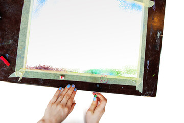 Hand starting pastel drawing on paper with masking tape frame. Top view of hands beginning a pastel...