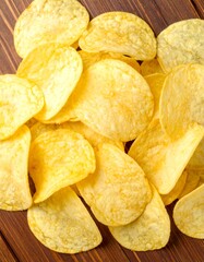 Crispy potato chips on a wooden surface