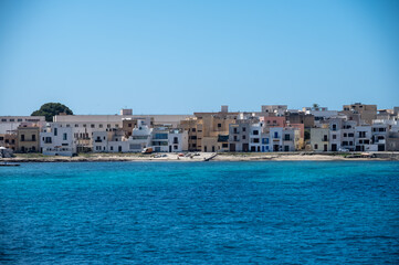 Boat trip and view on coastline of Favignana island with small village, shallow bays with clear...