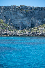 Boat trip and view on coastline of Favignana island with shallow bays with clear turquoise water,...