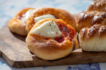 Fresh baked bread, pizza, focaccia or pizzetta with tomatoes, vegetables, sausage and cheese, street food in Palermo, Sicily, Italy, served outdoor for lunch