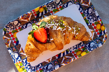 Italian breakfast, fresh baked butter croissant filled with ricotta cheese and jam, served outdoor...
