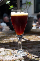 Belgian beer in glass in old brewery in Bruges, dubbel dark, tasty beverage, lunch with beer, tourist destination, Flanders, Belgium
