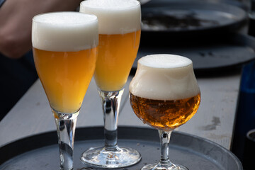 Belgian beer in glass in old brewery in Bruges, strong triple, tasty beverage, lunch with beer, tourist destination, Flanders, Belgium