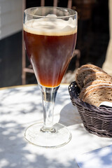 Belgian beer in glass in old brewery in Bruges, dubbel dark, tasty beverage, lunch with beer, tourist destination, Flanders, Belgium