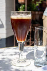 Belgian beer in glass in old brewery in Bruges, dubbel dark, tasty beverage, lunch with beer, tourist destination, Flanders, Belgium