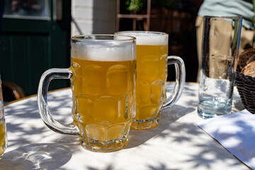 Belgian beer in glasses in old brewery in Bruges, light or dark, tasty beverage, lunch with beer, tourist destination, Flanders, Belgium