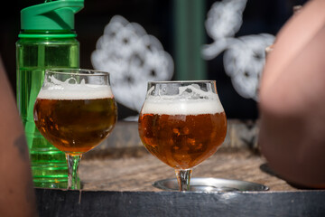 Belgian beer in glasses in old brewery in Bruges, light or dark, tasty beverage, lunch with beer, tourist destination, Flanders, Belgium