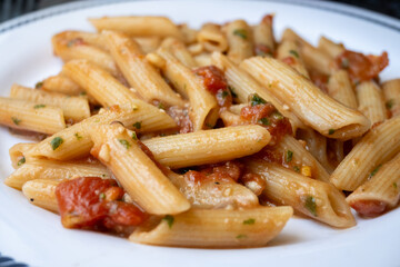 Italian everyday food, cooked pasta penne with tomatoes sauce, garlic and parsley