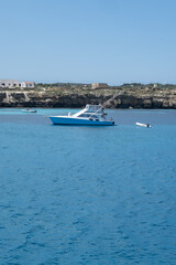 Boat trip and view on coastline of Favignana island with shallow bays with clear turquoise water, tuff rocks, abandoned quarries, caves, Egadi Islands near Sicily, Italy