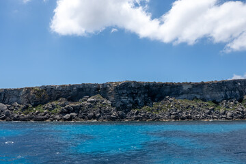 Coastline of Favignana island with tuff rocks, cultural heritage abandoned quarries, caves, ancient extraction of calcarenite, stone used for building, Egadi Islands near Sicily, Italy