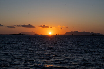 Sunset at Stagnone of Marsala, brackish lagoon and nature reserve near Marsala, Sicily, Italy, unique ecosystem with shallow, warm water, salt pans, and ancient windmills.