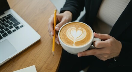 Business professional holding heart latte art cappuccino coffee with pencil during creative work planning session