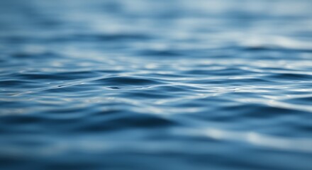 Calm blue water surface with gentle ripples and soft natural light creating peaceful aquatic texture for wellness and relaxation themes