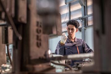Factory technician focusing on machine calibration in an industrial setting. Precision engineering,...