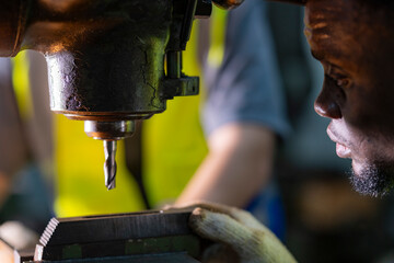 Skilled worker focused on operating machinery in a factory. Wearing high visibility vest and gloves, demonstrating precision, technical ability, safety, and industrial expertise.